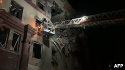 This photograph released by the Ukrainian State Emergency Service shows Ukrainian rescuers working in a residential building partially destroyed after Russian missile strikes in Zaporizhzhia, Oct. 18, 2023.