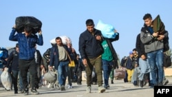 Afganistanski imigranti deportovani iz Irana, nose svoje stvari u reistrovanom centru u Islam Kali, pograničnom gradu u pokrajini Herat, 6. novembra 2023.