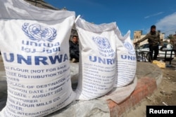 Displaced Palestinians wait to receive United Nations Relief and Works Agency aid during the ongoing conflict between Israel and the Palestinian Islamist group Hamas in Rafah in the southern Gaza Strip, March 7, 2024.