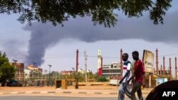Des hommes marchent dans une rue de Khartoum le 8 juin 2023. 