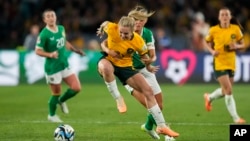 Jwez Ostralyen Ellie Carpenter (a goch) goumen pou pran balon an nan men Irlandez Katie Mc Cabe nan match ouveti Mondyal Foutbol Feminin FIFA a, nan Sydney, Ostrali, 20 Jiye, 2023. 