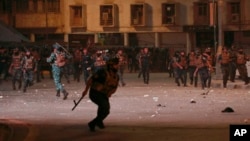 FILE - Security forces try to disperse anti-government protesters in Baghdad, Oct. 25, 2022. At least two people were killed Dec. 7, 2022, in southern Iraq when security forces fired on a crowd protesting the sentencing of an activist to three years in prison for a Twitter post.