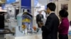 FILE - Visitors look at a nuclear power plant station model by American company Westinghouse at the World Nuclear Exhibition 2014, the trade fair event for the global nuclear energy sector, in Le Bourget, near Paris Oct. 14, 2014.
