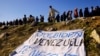 Migrantes venezolanos, algunos expulsados de EEUU a México bajo el Título 42 y otros que aún no han cruzado tras las nuevas políticas migratorias, hacen fila para recibir alimentos donados mientras una pancarta que dice &quot;Joe Biden Venezuela te necesita&quot; yace a orillas del Río Bravo, en Ciudad Juárez, México, el 26 de octubre de 2022. REUTERS/José Luis González&nbsp;&nbsp;