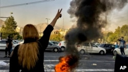 FILE- A police motorcycle burns during a protest over the death of Mahsa Amini, in Tehran, Sept. 19, 2022. (AP Photo/Middle East Images, File)