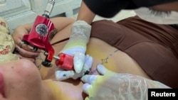 Manel Mahdouani, une tatoueuse tunisienne qui fait revivre les dessins berbères traditionnels, tatoue une cliente à Tunis, Tunisie le 2 septembre 2022. (Photo Reuter/Jihed Abidellaoui)