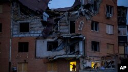 People check the damage to apartments hit by a Russian missile in Mykolaiv, Oct. 23, 2022.