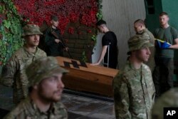 Soldiers of the Azov regiment pay their last respects to a serviceman killed in battle against Russian troops, in a city crematorium in Kyiv, Ukraine, July 21, 2022.