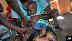 A baby from the Malawi village of Tomali is injected with the world's first vaccine against malaria in a pilot program, in Tomali, Dec. 11, 2019. (AP Photo/Jerome Delay, File)