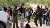 Migrantes que buscan asilo, en su mayoría de Venezuela y Cuba, son procesados por agentes de Aduanas y Protección Fronteriza después de cruzar el río Grande hacia EEUU desde México en Eagle Pass, Texas, el 13 de julio de 2022. REUTERS/Go Nakamura