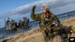 Na ovoj slici koju je dostavila Organizacija Sjevernoatlantskog pakta, američki marinac maše svojim trupama naprijed tokom vježbe Cold Response 22, Norveška, mart 2022.