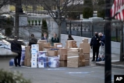 Arhiv - Ljudi pored kombija nakon što su kutije iznete iz Eisenhowerovog ureda u kompleksu Bijele kuće u Washingtonu.