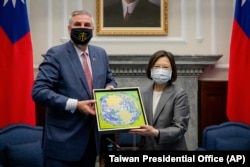 Presiden Taiwan Tsai Ing-wen berjabat tangan dengan Gubernur Indiana AS Eric Holcomb dalam pertemuan di kantor Kepresidenan di Taipei, Taiwan, Senin, 22 Agustus 2022. (Kantor Kepresidenan Taiwan via AP)
