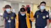 Two suspect were deported from Bangkok and believed to be involved in scam cases in Cambodia as they arrive back at the Taoyuan International Airport in Taiwan on Thursday, Aug. 18, 2022. (Taiwan Criminal Investigation Bureau via AP)