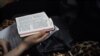 FILE - A woman holding a bible during a Christmas Eve service held by members of an underground church, at an apartment in Beijing, Dec. 24, 2014.