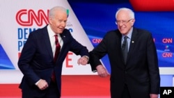 លោក Joe Biden (រូប​ឆ្វេង) និង​លោក Bernie Sanders ស្វាគមន៍​គ្នា មុន​ពេល​ចូលរួម​ក្នុង​ការ​ជជែក​ដេញ​ដោល​សម្រាប់​តំណែង​បេក្ខជន​ប្រធានាធិបតី​ខាង​គណបក្ស​ប្រជាធិបតេយ្យ​ នៅ​ក្នុង​រដ្ឋធានី​វ៉ាស៊ីនតោន កាលពី​ថ្ងៃទី១៥ ខែមីនា ឆ្នាំ២០២០។