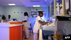 Une infirmière habille un bébé nouveau-né, près d'une machine de photothérapie dans l'unité de crèche et de soins intensifs de la maternité de la Maternité de Mayotte à Mamoudzou, le 14 mars 2018.