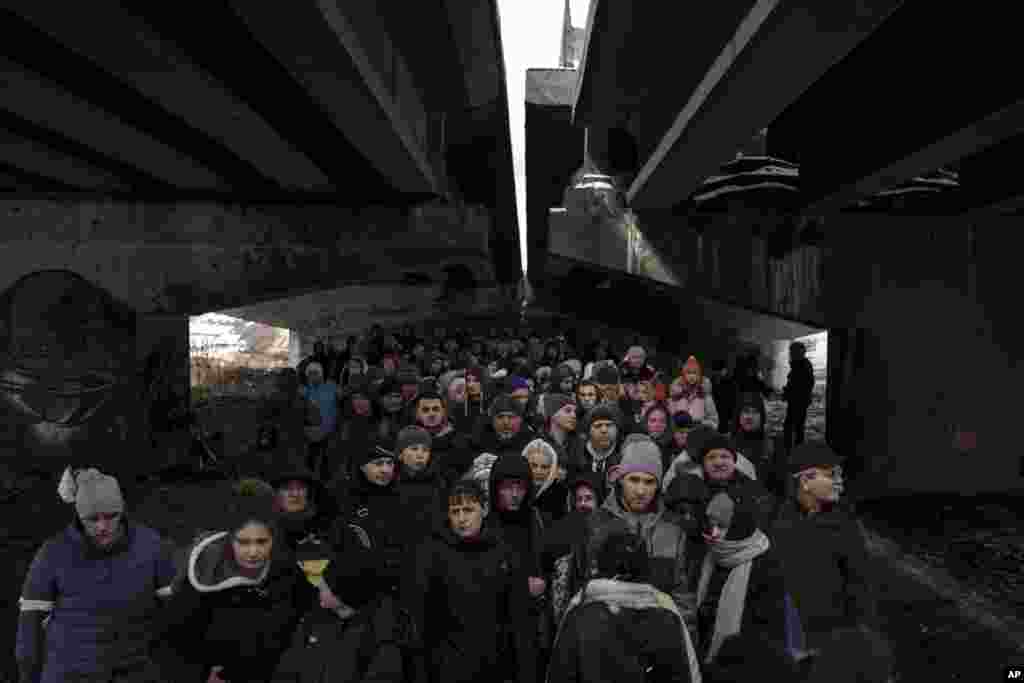 Ukrainians crowd under a destroyed bridge as they try to flee crossing the Irpin river, March 8, 2022.&nbsp;Efforts to put in place cease-fires along humanitarian corridors have repeatedly failed amid Russian shelling.