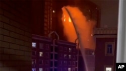 Petugas pemadam kebakaran menyemprotkan air ke api di sebuah gedung apartemen di Urumqi di Daerah Otonomi Uyghur di Xinjiang, China barat laut, Kamis malam 24 November 2022.