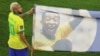 Le Brésilien Neymar porte une bannière à l'effigie de Pelé pendant la Coupe du monde au Qatar, le 5 décembre 2022.