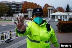 Čuvar sprečava slikanje na ulazu u Univerzitet Cingua u Pekingu. (Foto: REUTERS/Thomas Peter)