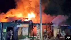 In this handout photo released by the Russian Emergency Ministry Press Service, firefighters try to extinguish a fire at a nursing home in the Siberian city of Kemerovo, Russia, Dec. 24, 2022. 