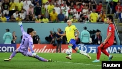 Richarlison de Brasil en acción contra el guardameta Kim Seung-gyu de Corea del Sur, en un partido que concluyó 4-1 para los cariocas y les dio el pase a cuartos de final, en Doha, Qatar, el 5 de diciembre de 2022.
