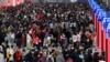 In this photo released by Xinhua News Agency, people with their luggage prepare to catch their trains at the North Railway Station in Shenzhen in south China's Guangdong province, Jan. 7, 2023. 