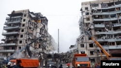 Emergency personnel work at the site where an apartment block was heavily damaged by a Russian missile strike, amid Russia's attack on Ukraine, in Dnipro, Ukraine, Jan. 15, 2023. 