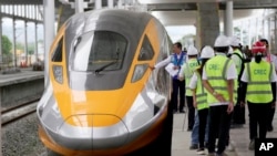 Sejumlah pejabat dan pekerja menginspeksi unit kereta cepat Jakarta-Bandung di stasiun Tegalluar, Jawa Barat, pada 13 Oktober 2022. (Foto: AP/Dita Alangkara)