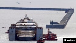 Kapal Costa Concordia didorong ke pelabuhan Genoa, Italia barat laut, di mana kapal tersebut akan dipreteli, 27 Juli 2014. 