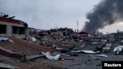 Smoke rises amid damaged buildings following an attack on the Yavoriv military base, as Russia's invasion of Ukraine continues, in Yavoriv, Lviv Oblast, Ukraine, March 13, 2022 in this picture obtained from social media. (@BackAndAlive/via Reuters) 