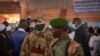 Un agent de sécurité privé du groupe russe Wagner (G) se tient à côté d'un soldat centrafricain lors d'un rassemblement du parti politique Mouvement des Cœurs Unis (MCU) au stade Omnisport de Bangui le 18 mars 2022. (Photo de Barbara DEBOUT /AFP)