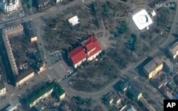 This satellite image provided by Maxar Technologies shows the Mariupol Drama Theater in Mariupol, Ukraine, March 14, 2022. Ukrainian officials say Russian forces destroyed the theater where hundreds of people were sheltering. There was no immediate word o