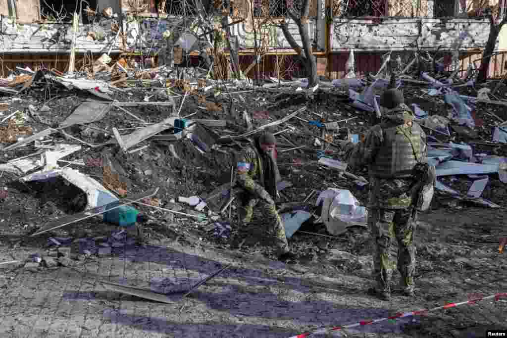 Ushtarët ukrainas inspektojnë dëmet në një ndërtesë banimi pas bombardimeve ruse në Kiev, më 15 mars 2022.&nbsp;