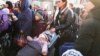 Refugees with children wait for a transport after fleeing the war from neighboring Ukraine at a railway station in Przemysl, Poland, March 24, 2022.