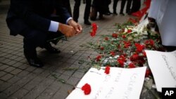 A man leaves carnations at the Saturday explosion site in Istanbul, March 20, 2016. 