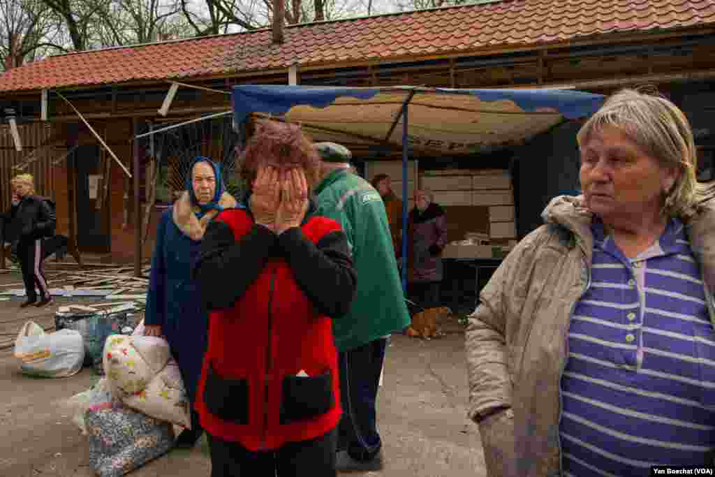A woman evacuated from a village recently under Russian control cries as she remembers the battle that was fought close to her house, in Kharkiv, April 29, 2022.