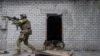A Ukrainian serviceman patrols during a reconnaissance mission in a recently retaken village on the outskirts of Kharkiv, east Ukraine, May 14, 2022.