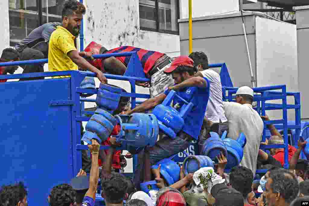 Şri-Lanka - Kolombo şəhərində bütün gecəni təchizat üçün növbə gözləyən qəzəbli kütlə yük maşınından qaz balonlarını götürüb aparır. &nbsp;