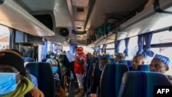 FILE - A Red Cross worker takes roll call in one of the many buses planned for the return home of Central African Republic refugees in Gado, Cameroon, Dec. 2, 2020.