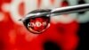 FILE - An illustration taken Nov. 9, 2020, features "COVID-19" in a drop on a syringe needle. The U.S. will keep in place the public health emergency status of the pandemic, allowing millions to receive free tests, vaccines and treatments until at least April, officials said. 