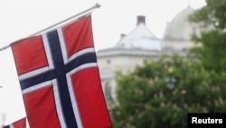 FILE - Norwegian flags flutter at Karl Johans street in Oslo, Norway, May 31, 2017. 