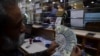 En esta imagen tomada el 10 de enero de 2023, un comerciante cuenta dólares estadounidenses en un mercado de cambio de dinero en Karachi, Pakistán.