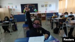 FILE - Students attend a class at a primary school, as schools reopen amid COVID-19 outbreak, in Santiago, Chile, March 1, 2021.