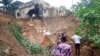 People inspect damage after heavy rains caused floods and landslides, on the outskirts of Kinshasa, Democratic Republic of Congo, Dec. 13, 2022.
