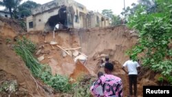 People inspect damage after heavy rains caused floods and landslides, on the outskirts of Kinshasa, Democratic Republic of Congo, Dec. 13, 2022.
