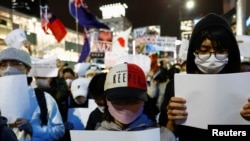 일본 도쿄에 사는 중국인들이 하얀 종이를 들고 본국에서 발생한 코로나 관련 항의 시위를 지지하는 집회에 참여하고 있다. (자료사진)
