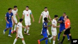 Pemain Iran berbicara dengan wasit Antonio Mateu, dari Spanyol, saat pertandingan sepak bola grup B Piala Dunia antara Iran dan Amerika Serikat di Stadion Al Thumama di Doha, Qatar, Rabu, 30 November 2022. (AP Photo/Luca Bruno)