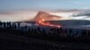 People gather to observe the eruption of the Mauna Loa volcano in Hawaii, Dec. 1, 2022.